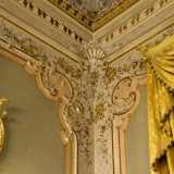 ...posizionate in elaborate composizioni murali con fregi a rialzo, festoni colorati e volti di putti situate negli angoli